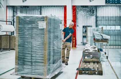 Empleado arrastrando palé con piezas de robots farmacéuticos