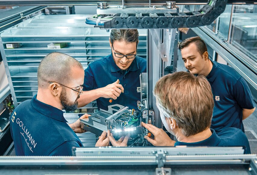 Empleados alrededor de una pieza de robot farmacéutico